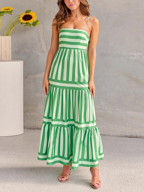 Model wearing a striped maxi dress with spaghetti straps and tiered skirt, elegant and fresh summer outfit.