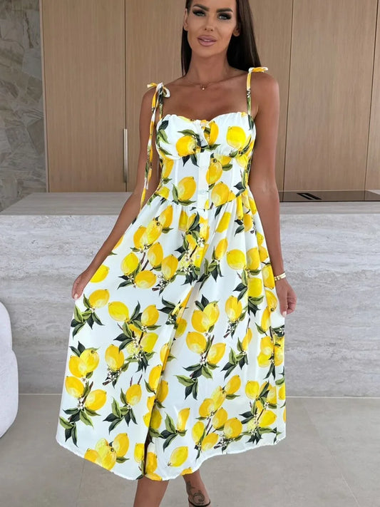 Model wearing a tropical print midi dress with tie straps, fitted bust and flared skirt, summer style available in multiple colours.