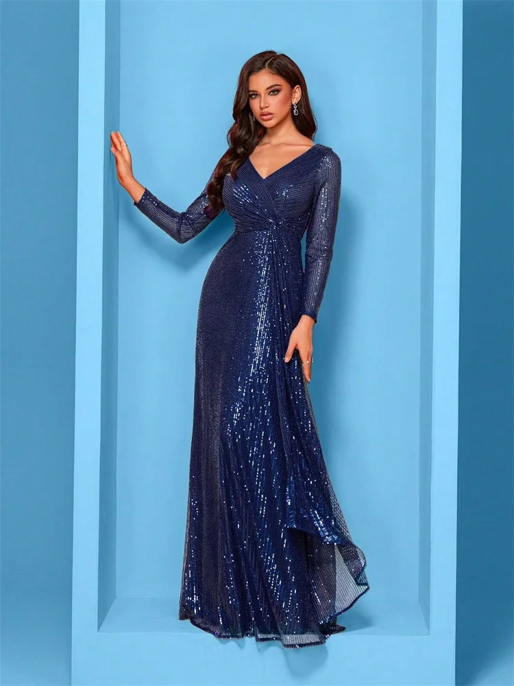 Woman wearing a sapphire blue long-sleeve sequin evening gown with a draped waist in a modern blue studio setting.