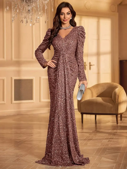 Woman wearing a rosé sequin full-length evening gown with structured shoulders and gathered waist in an elegant indoor setting.